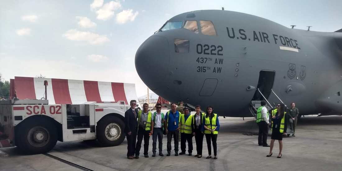 SATISERCOM crew and pushback tractor alongside a United States Air Force C-17 Globemaster III
