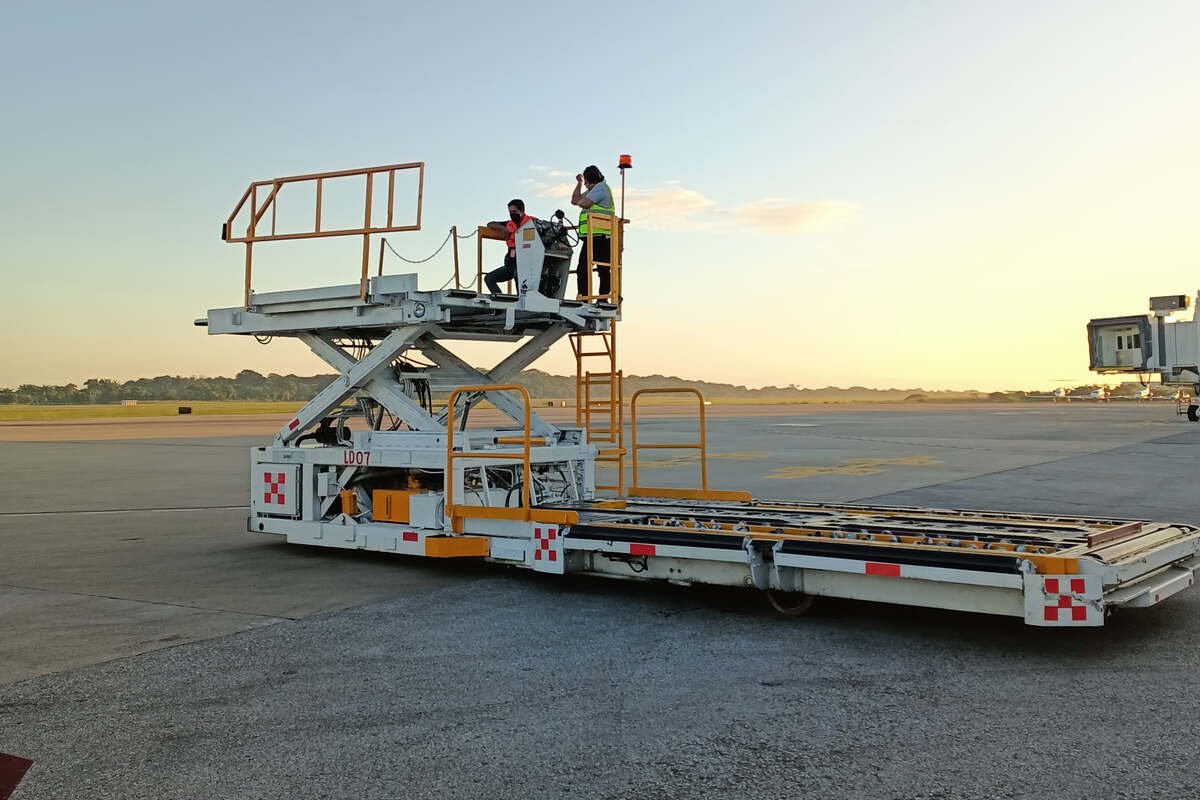 SATISERCOM crew operating ground support equipment beside an aircraft