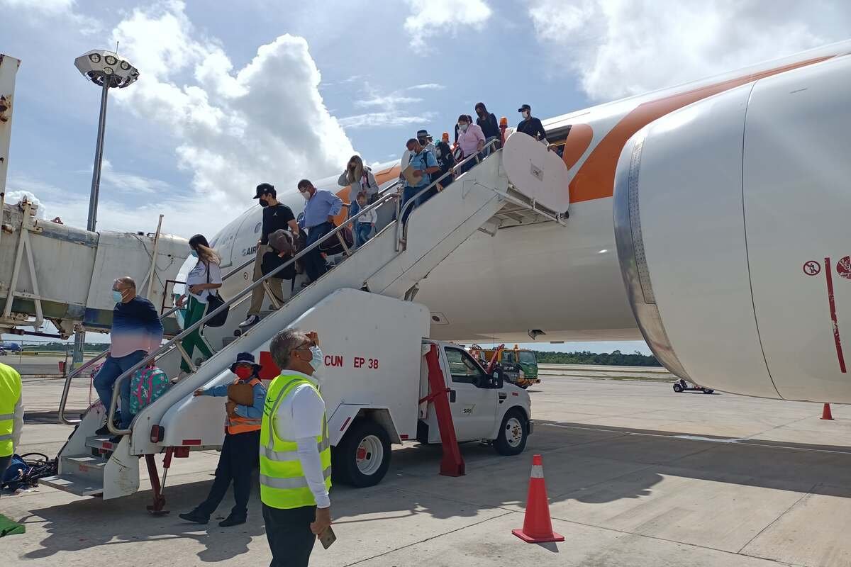 Passengers boarding with SATISERCOM staff coordinating on the ramp